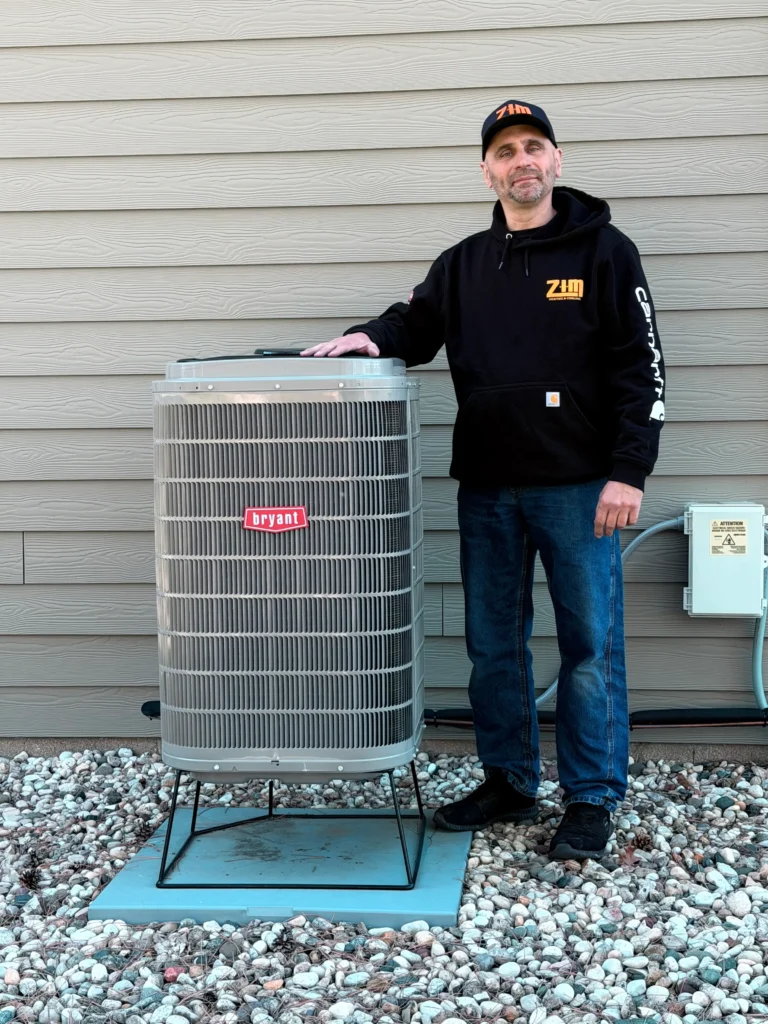 Zim Heating and Cooling technician servicing HVAC Waukesha WI air conditioner outside